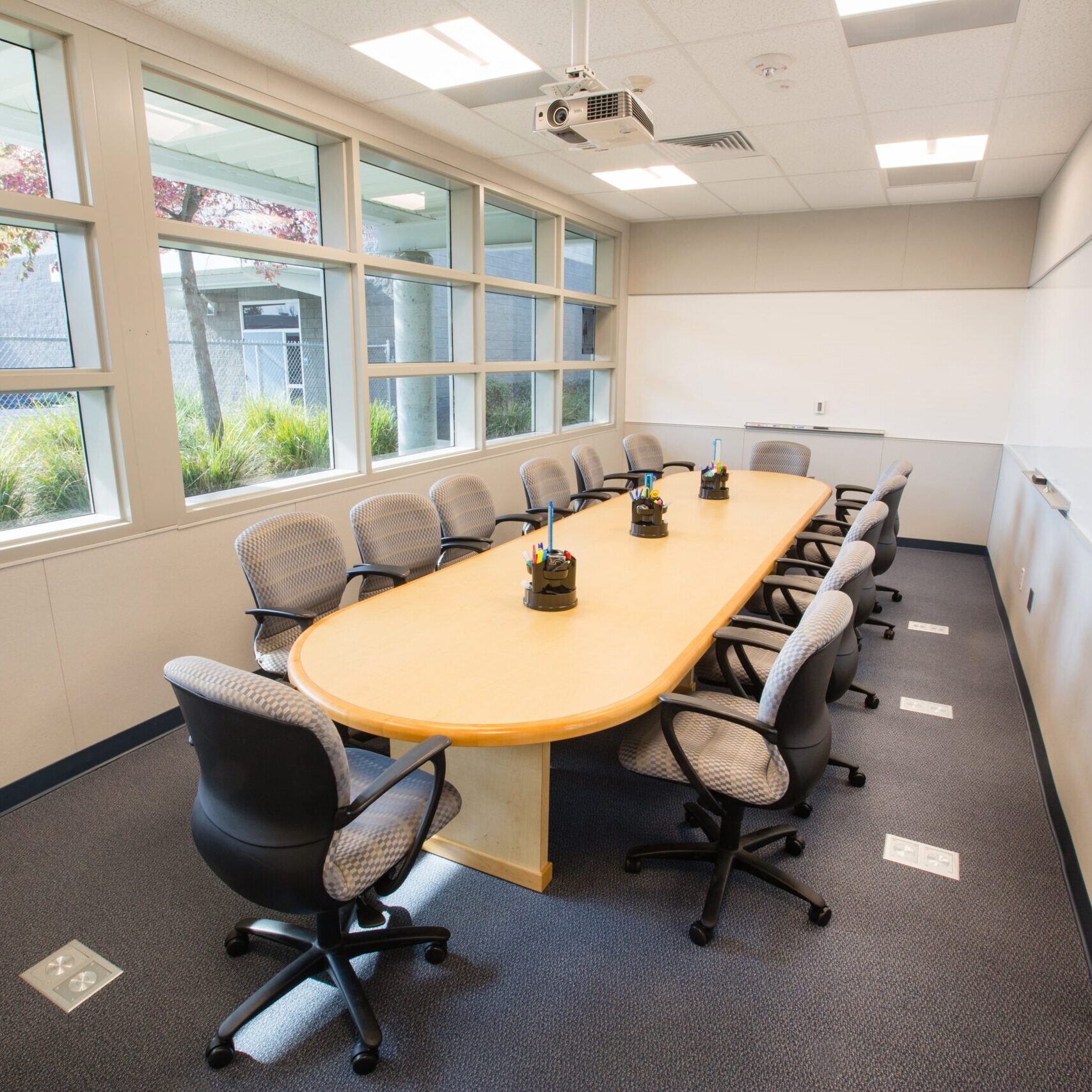 interior of clovis east high school in a board room with a long wooden desk with twelve office desks neatly arranged