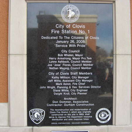 A close-up shot of a black granite dedication plaque for City of Clovis Fire Station No. 1. The plaque lists the date of dedication, "January 26, 2008," and the names of the City Council, staff members, architect Don Dommer Associates, and contractor Durham Construction. It also notes that the station was originally constructed on the site in 1969.
