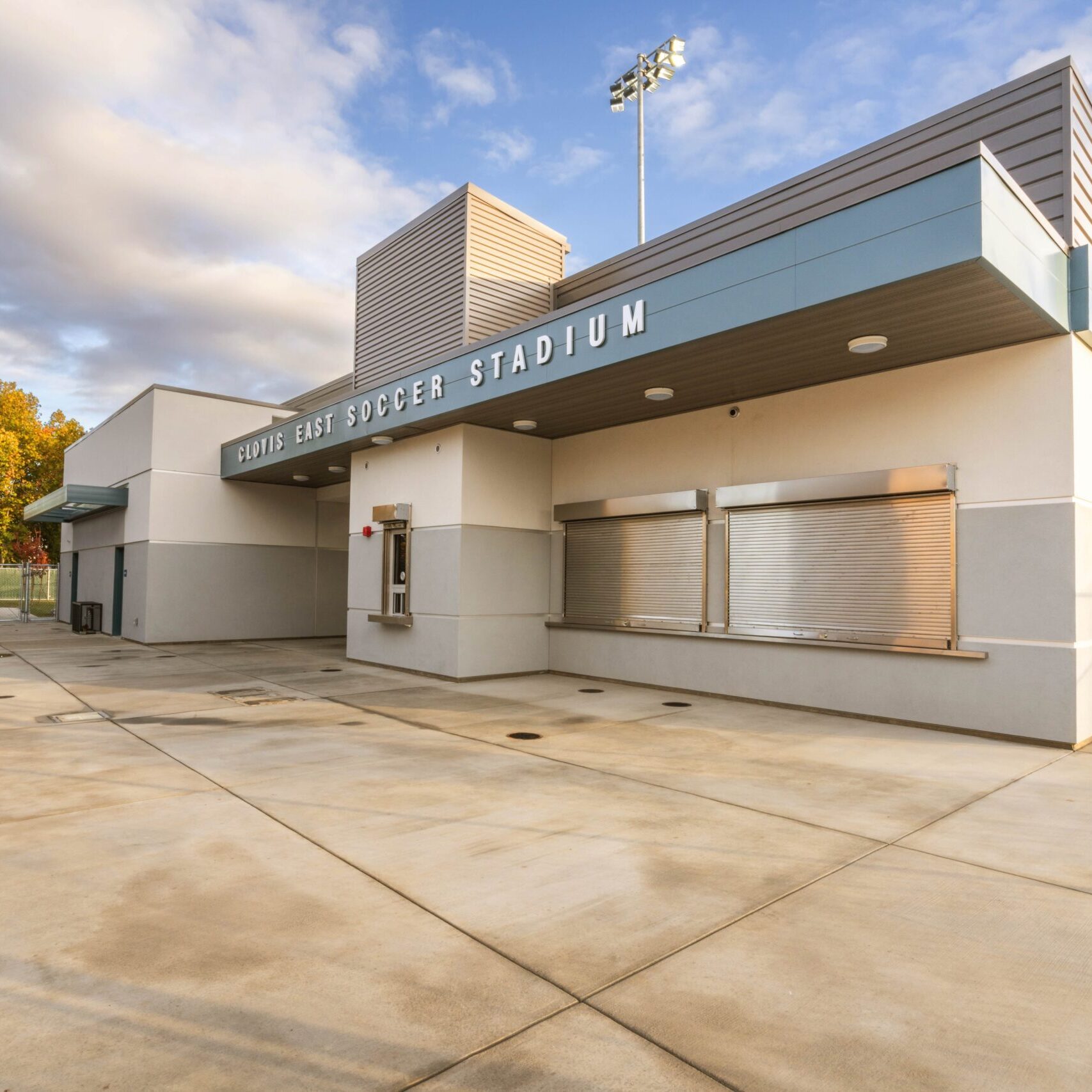 A ground-level shot of the stadium's main building, which has "CLOVIS EAST SOCCER STADIUM" written on the facade.